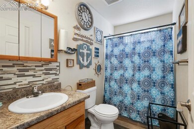 Bathroom with tasteful backsplash, toilet, hardwoo