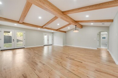 Unfurnished living room with baseboards, arched wa