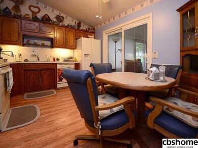 Wood laminate flooring, dinette, and enclosed all-season sunroom through sliding glass doors. Plenty of counter space!
