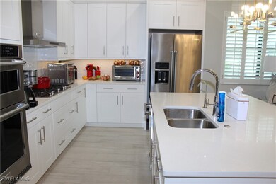 Kitchen featuring light countertops, wall chimney