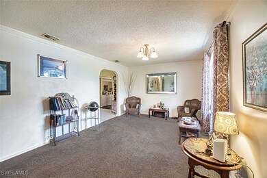 Living area with a textured ceiling, visible vents
