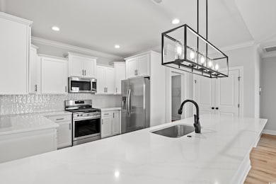 Kitchen with light stone countertops, appliances w