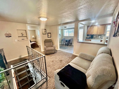Carpeted living room featuring baseboards and a textured ceiling