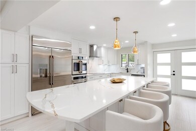 Kitchen with light stone counters, a kitchen islan