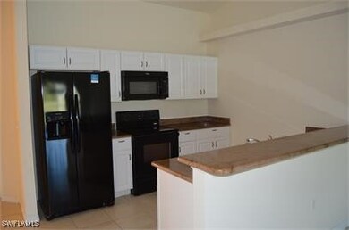 Kitchen featuring kitchen peninsula, white cabinet
