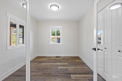 Empty room featuring dark wood-style flooring and baseboards