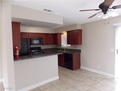 Kitchen featuring dark granite countertops, tile f