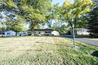 Spacious front yard with large trees.