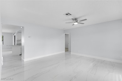 Empty room featuring ceiling fan and a textured ce