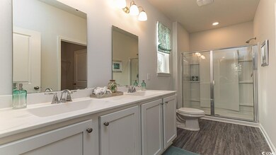 Bathroom featuring a shower with door, vanity, woo
