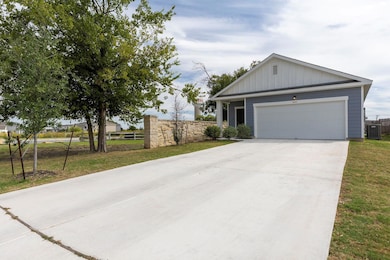Single story home with board and batten siding, a garage, and driveway
