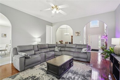 Living room with arched walkways, wood-type floori