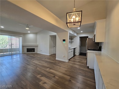 Kitchen featuring white cabinetry, pendant lighting, dark wood-style flooring, stainless steel appliances, and a ceiling fan
