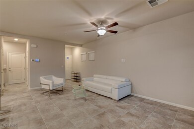Living area featuring visible vents, ceiling fan, and baseboards