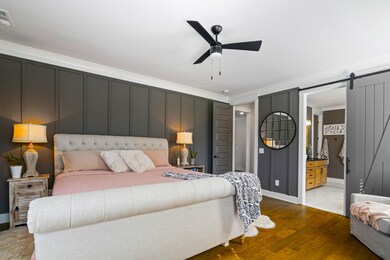 Beautiful Primary Suite with a peek of the Spa Bath beyond the Barn Door