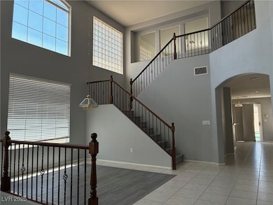 Stairway with a high ceiling, tile patterned floor
