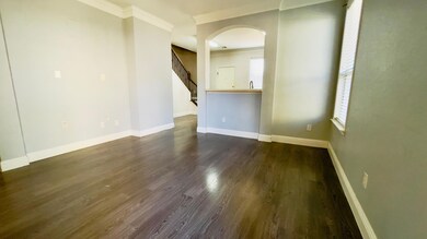 Empty room with dark wood-type flooring, baseboar
