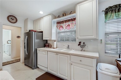 Kitchen with dishwasher, a sink, light tile patter