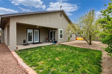 Rear view of property featuring fence, ceiling fan