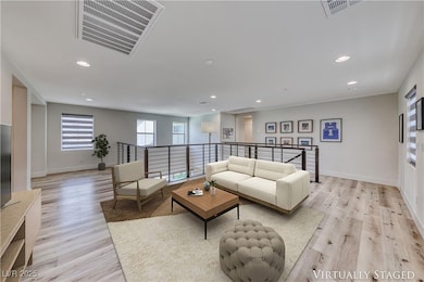 Living area with light wood finished floors, reces