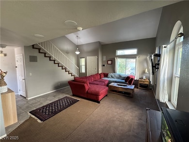 Living area with a textured ceiling, vaulted ceili