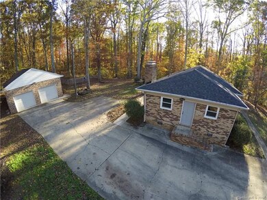 More parking around back with 2-car garage big enough for a workshop or storage in addition to parking 2 cars. Side entryway to living room with fireplace.