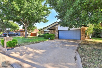 View of front of home with a garage and a front ya