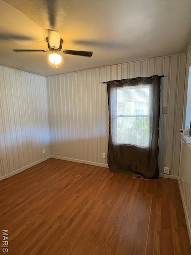 Spare room with dark wood-type flooring, a ceiling fan, and a textured ceiling