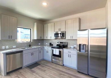 Kitchen with stainless steel appliances, light wo