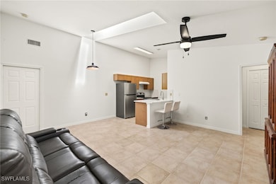 Living area with a ceiling fan, visible vents, bas