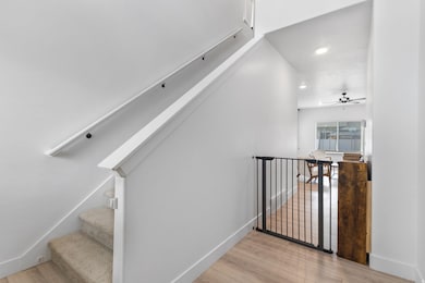 Staircase featuring wood finished floors, a ceiling fan, and recessed lighting