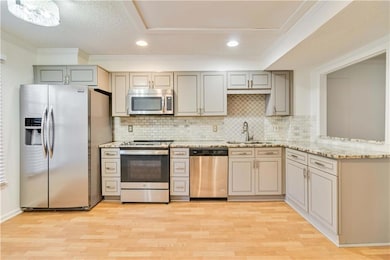 Kitchen with light wood-style flooring, a sink, ap