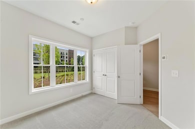 Unfurnished bedroom with light colored carpet and a closet