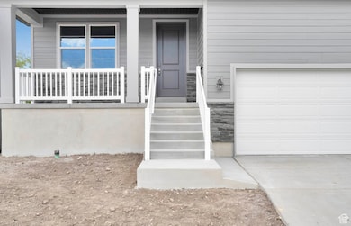 Property entrance with a porch, stone siding, and concrete driveway