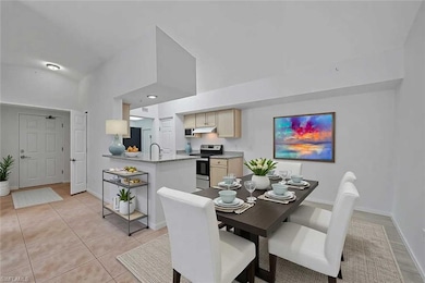 Dining room with light tile patterned flooring, baseboards, and high vaulted ceiling