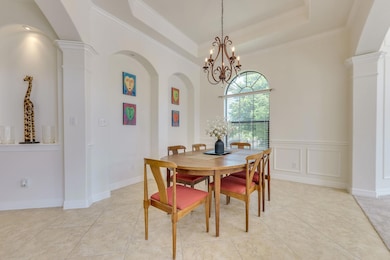 Dining area featuring arched walkways, light tile