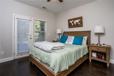 Bedroom featuring access to exterior, wood-type flooring, baseboards, and ceiling fan