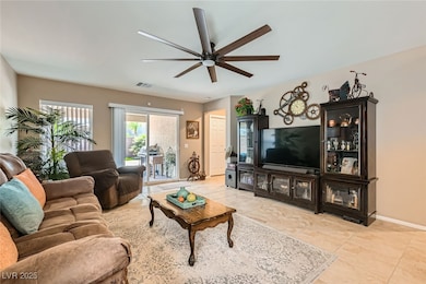 Living room with a ceiling fan and light tile patt