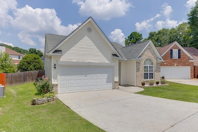 Traditional-style home featuring driveway, an attached garage, brick siding, and roof with shingles