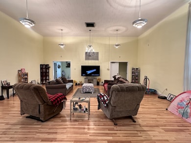 Living area featuring wood finished floors and a high ceiling