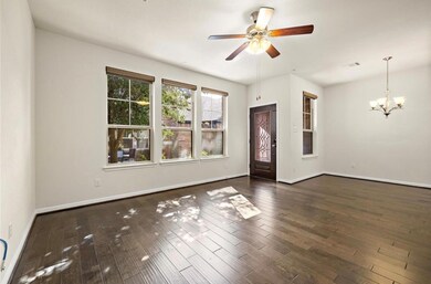 Unfurnished room featuring a ceiling fan, dark wood-style flooring, and a chandelier
