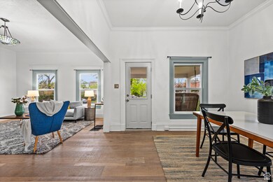 Foyer entrance featuring ornamental molding, wood finished floors, and a chandelier