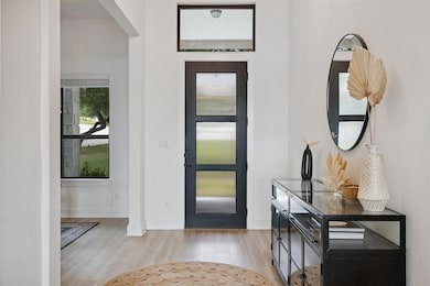 Entryway with wood finished floors and arched wal