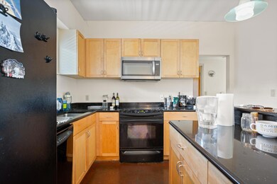 Kitchen featuring black appliances, light brown c