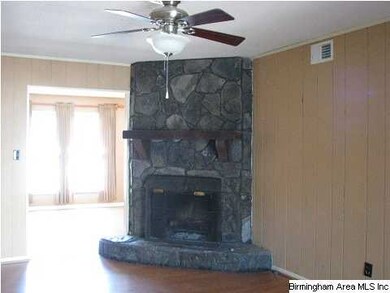 The rock fireplace is the focal point in the den.