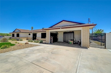 Ranch-style house with brick siding, driveway, an attached garage, and a gate