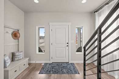 Entryway with light wood-type flooring, stairway, and recessed lighting