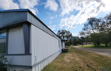 View of side of home with a yard