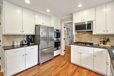 Kitchen featuring appliances with stainless steel finishes, white cabinets, ornamental molding, tasteful backsplash, and recessed lighting