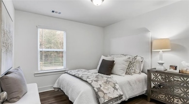 Bedroom with wood finished floors and baseboards